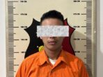 Tersangka kasus penganiayaan berinisial AW (26) saat diamankan di Mapolsek Bengkong. Foto: Ist