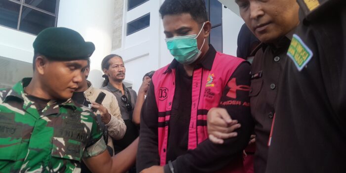 Salah satu tersangka kasus dugaan korupsi fasilitas kredit mikro pada salah satu Bank Cabang Milik Negara di Kota Tanjungpinang saat akan dibawa petugas ke Rutan. Foto: Rindu Sianipar