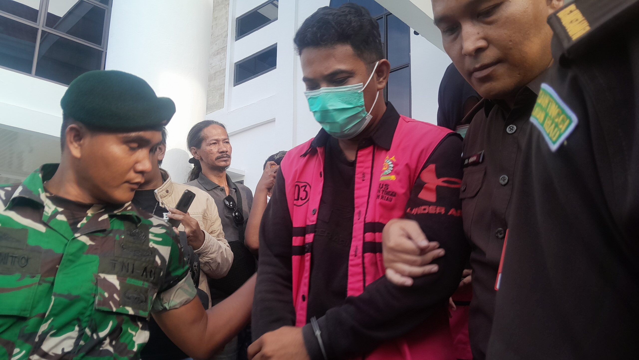 Salah satu tersangka kasus dugaan korupsi fasilitas kredit mikro pada salah satu Bank Cabang Milik Negara di Kota Tanjungpinang saat akan dibawa petugas ke Rutan. Foto: Rindu Sianipar