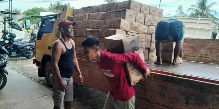 Sejumlah pekerja tampak menurunkan muatan berupa minyak goreng merek MinyaKita dari truk di salah satu gudang di Tanjungpinang, Selasa (23/06/2026). Foto: Rindu Sianipar