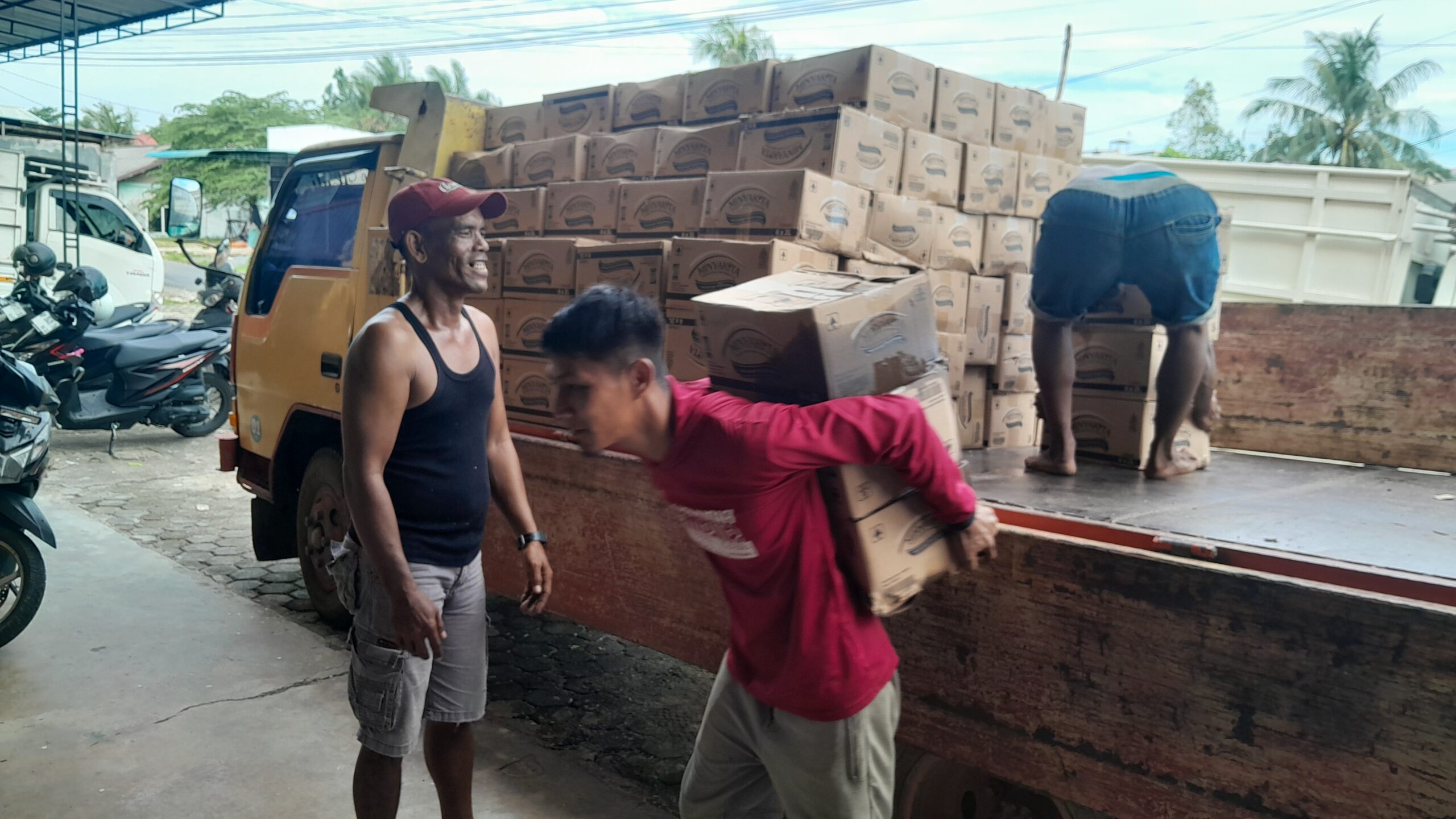 Sejumlah pekerja tampak menurunkan muatan berupa minyak goreng merek MinyaKita dari truk di salah satu gudang di Tanjungpinang, Selasa (23/06/2026). Foto: Rindu Sianipar