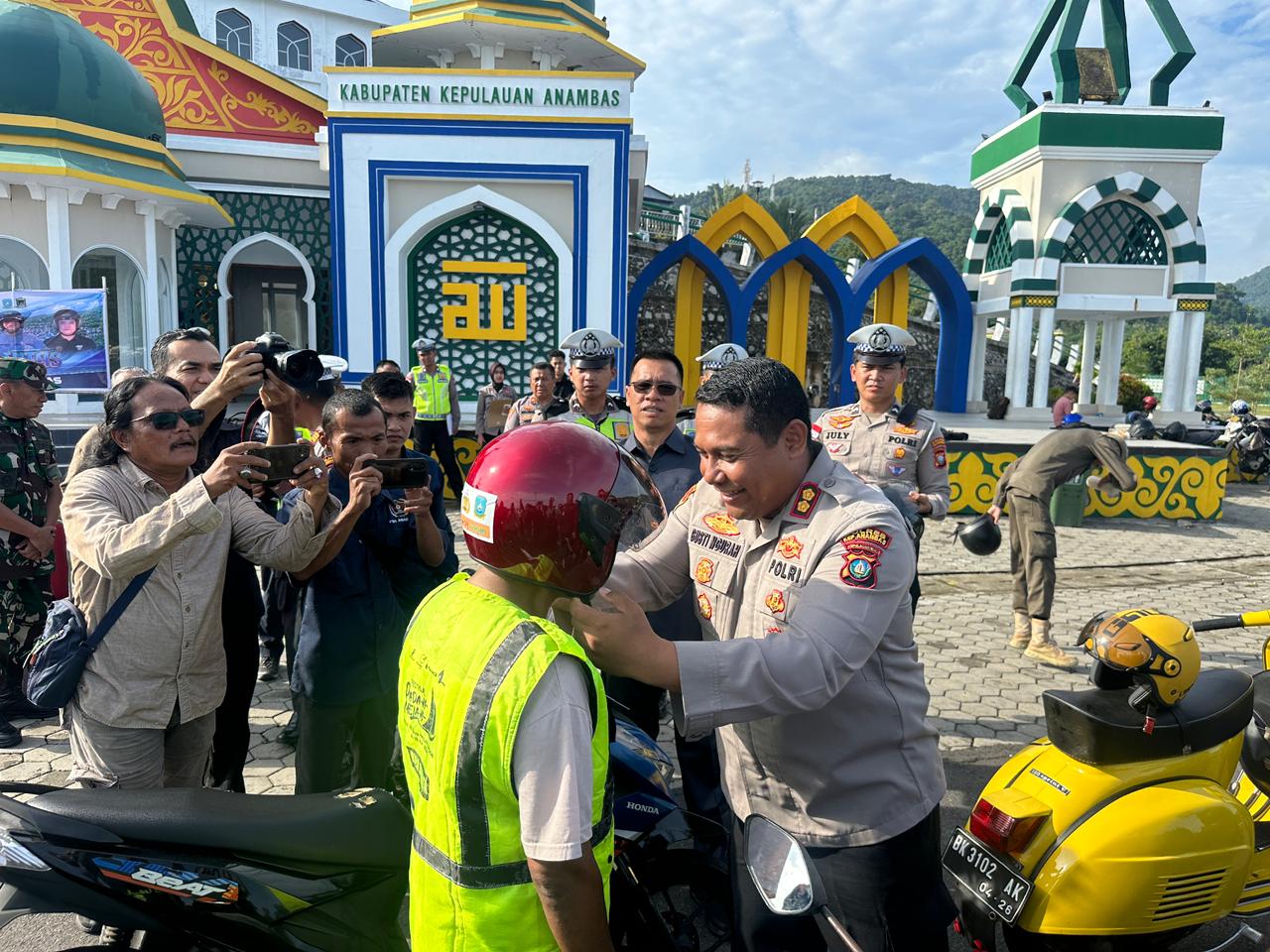 Kapolres Kepulauan Anambas, AKBP I Gusti Ngurah Agung Budianaloka membagikan helm kepada pengendara. Foto: Ist