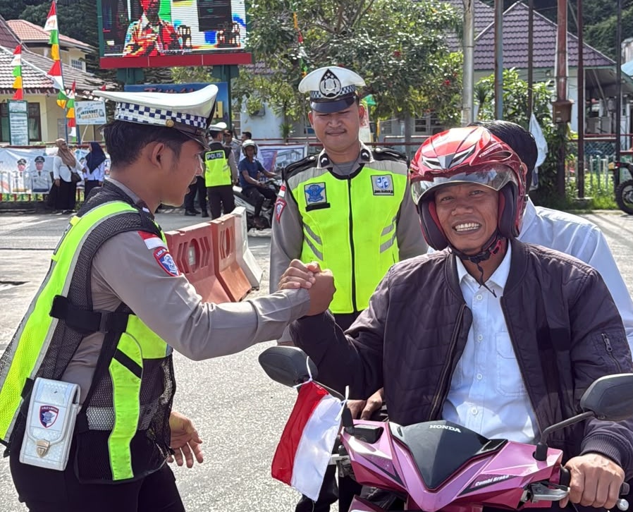 Personel Satlantas Polres Kepulauan Anambas membagikan bendera Merah Putih ke pengendara. Foto: Ist