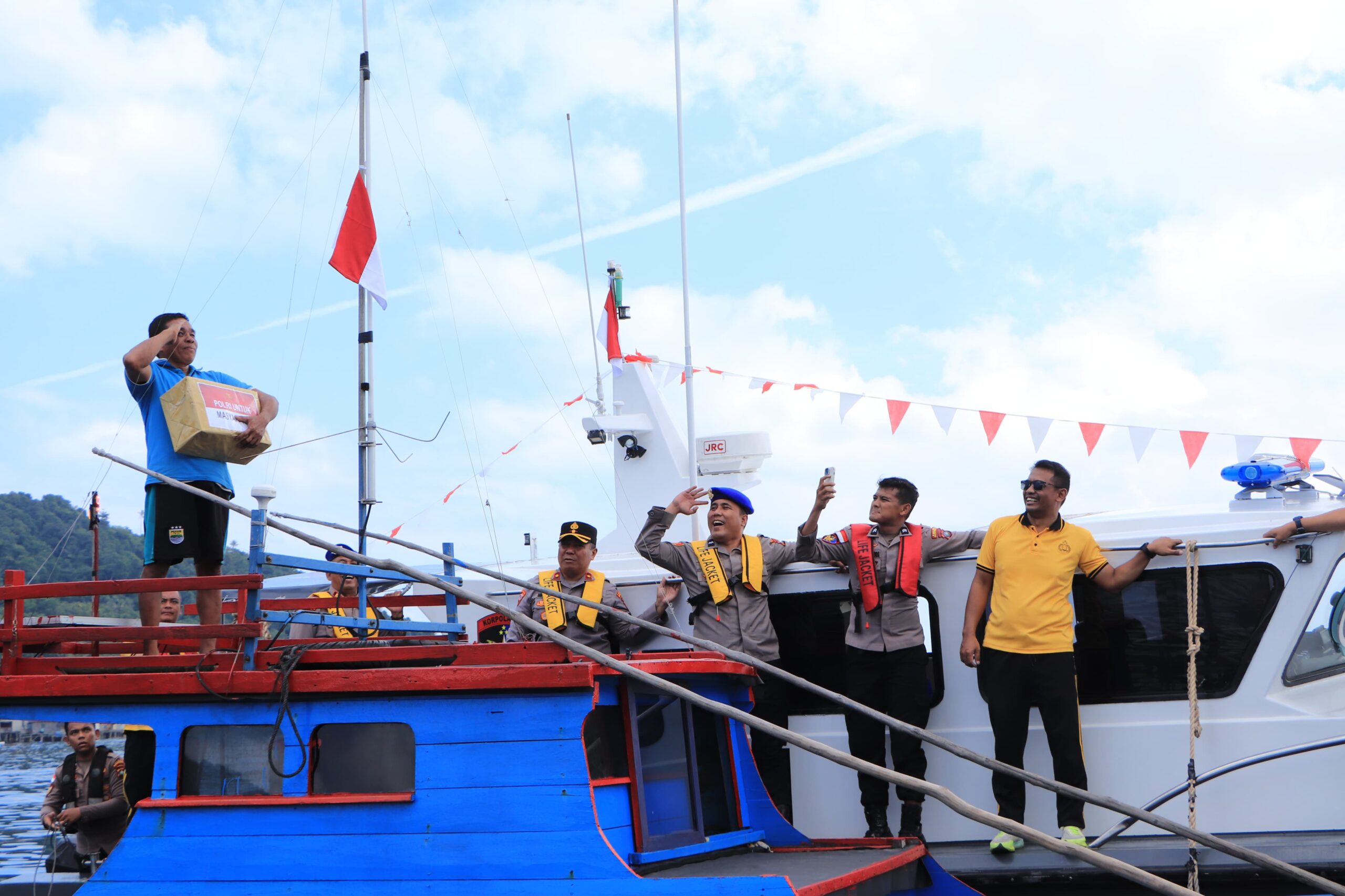 Polres Kepulauan Anambas membagikan Bendera Merah Putih dan paket bantuan sosial kepada masyarakat nelayan di Perairan Desa Sri Tanjung, Kecamatan Siantan. Foto: Ist