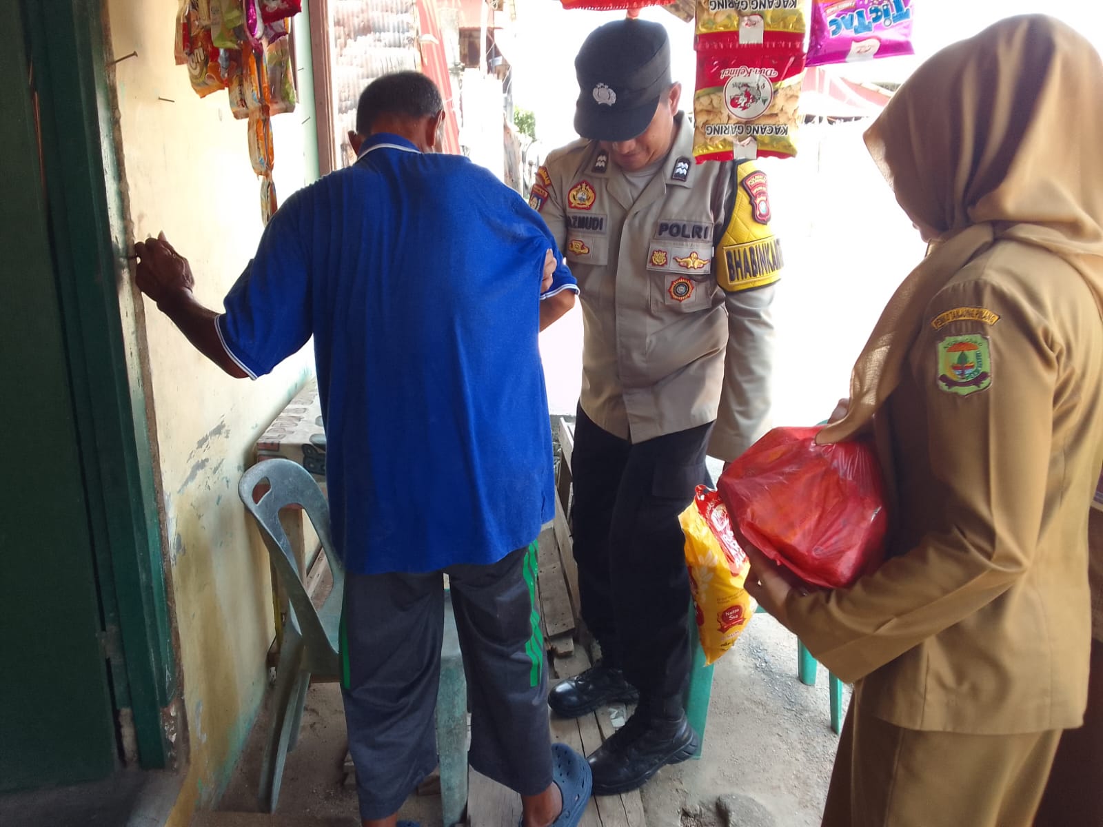 Bhabinkamtibmas Kelurahan Tanjung Unggat, Aiptu Razmudi saat membagikan Bansos kepada warga yang sedang sakit. Foto: Ist