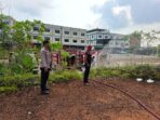 Seorang personel kepolisian tampak mengamankan proses pemadaman api yang membakar lahan kosong seluas sekitar satu hektare di Tanjungpinang. Foto: Ist