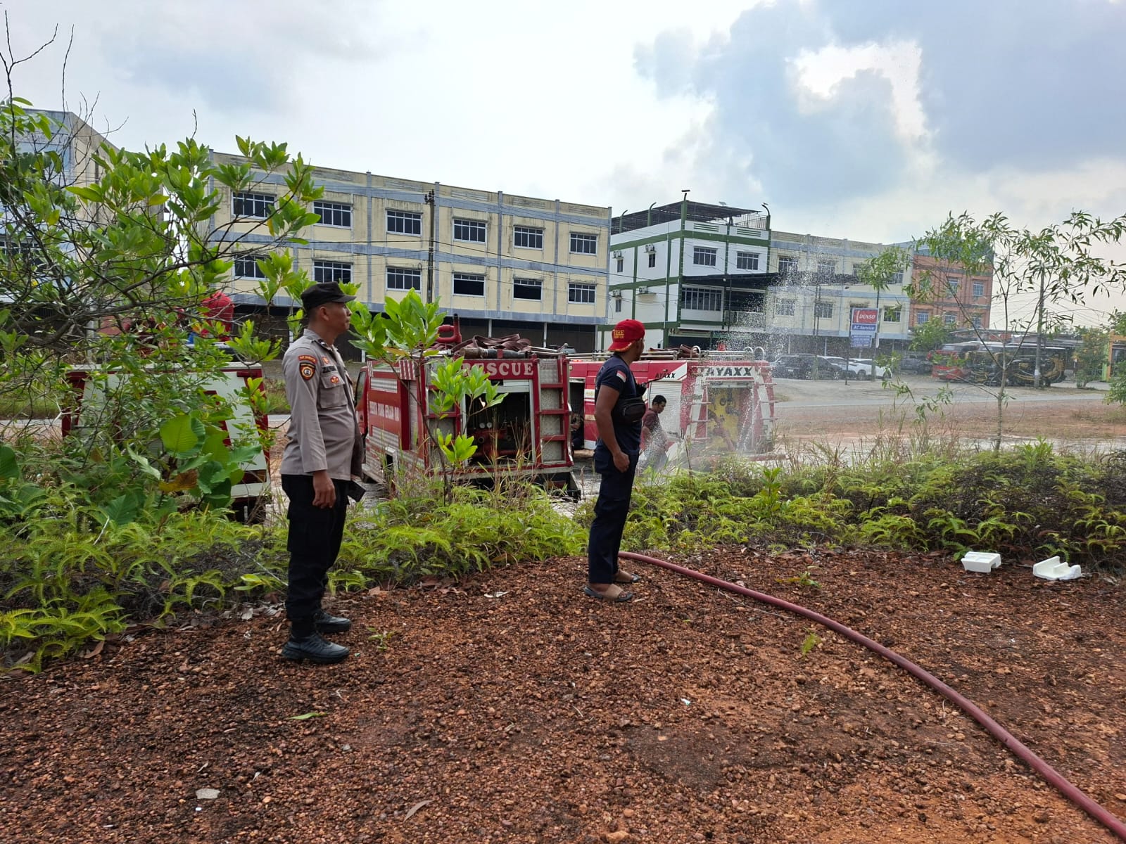 Seorang personel kepolisian tampak mengamankan proses pemadaman api yang membakar lahan kosong seluas sekitar satu hektare di Tanjungpinang. Foto: Ist